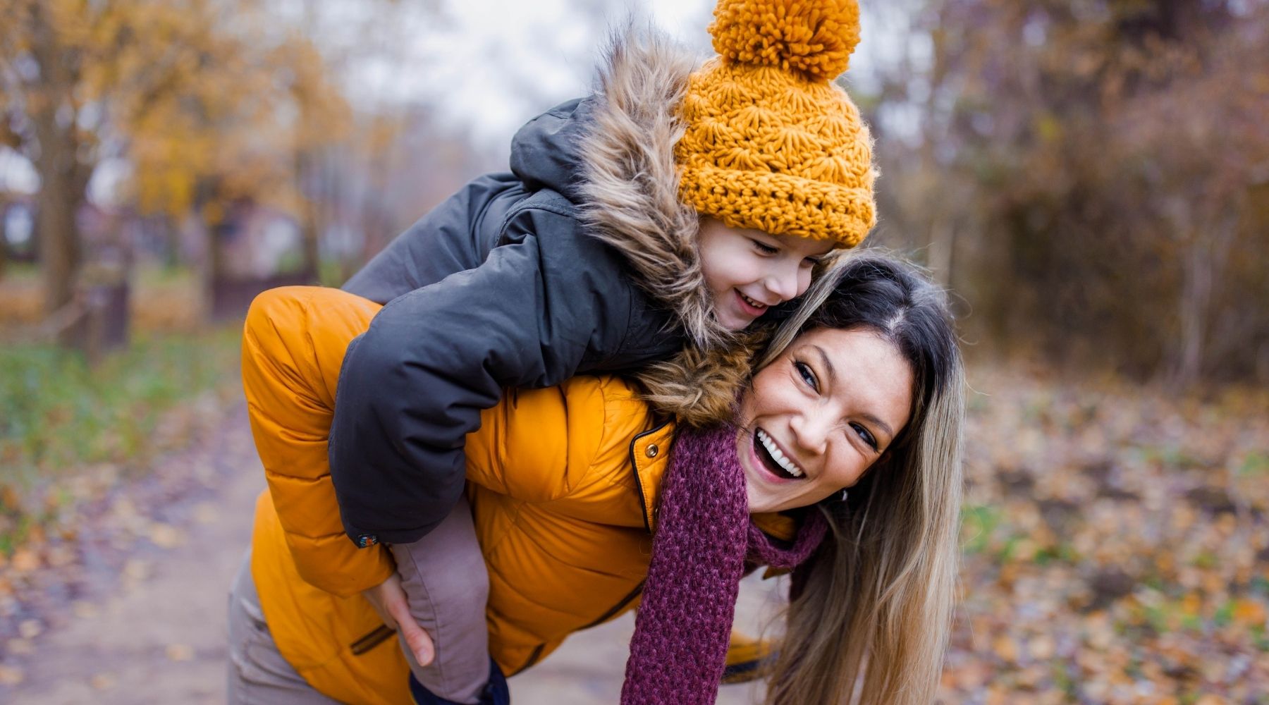 Frau trägt Kind am Rücken